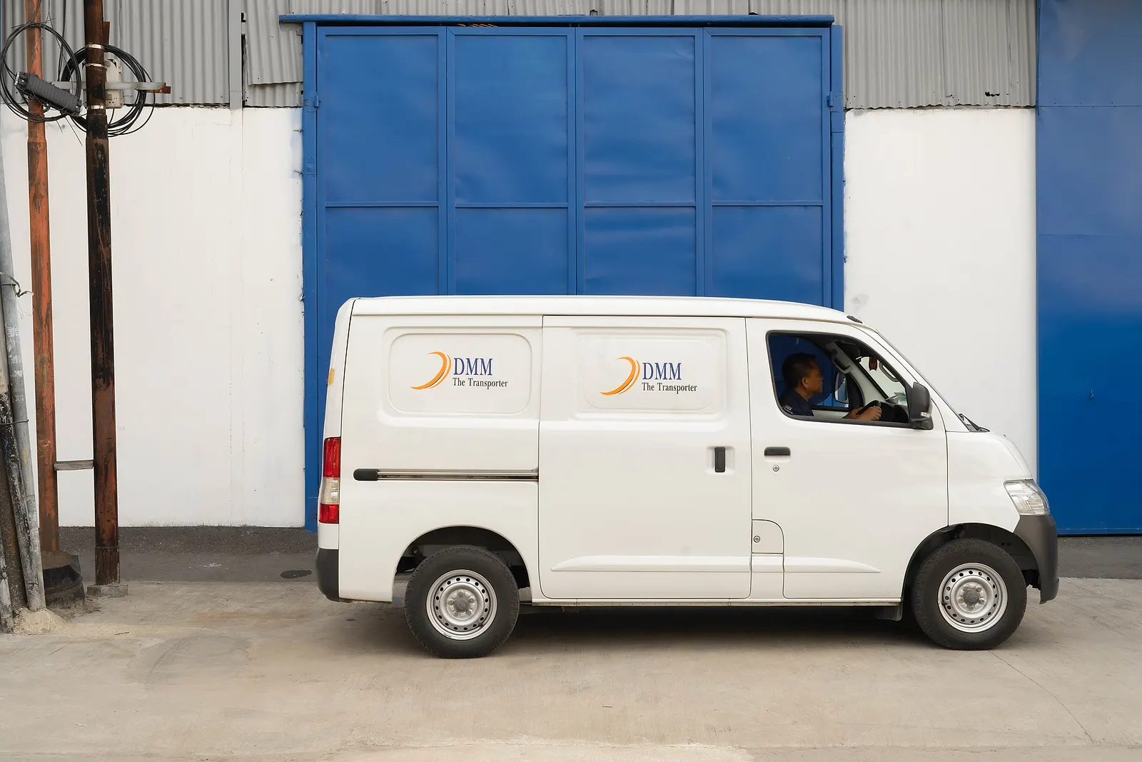 DMM operational vehicle in front of a warehouse